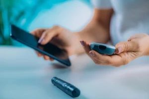 Doctor holding mobile phone and device for remote patient monitoring